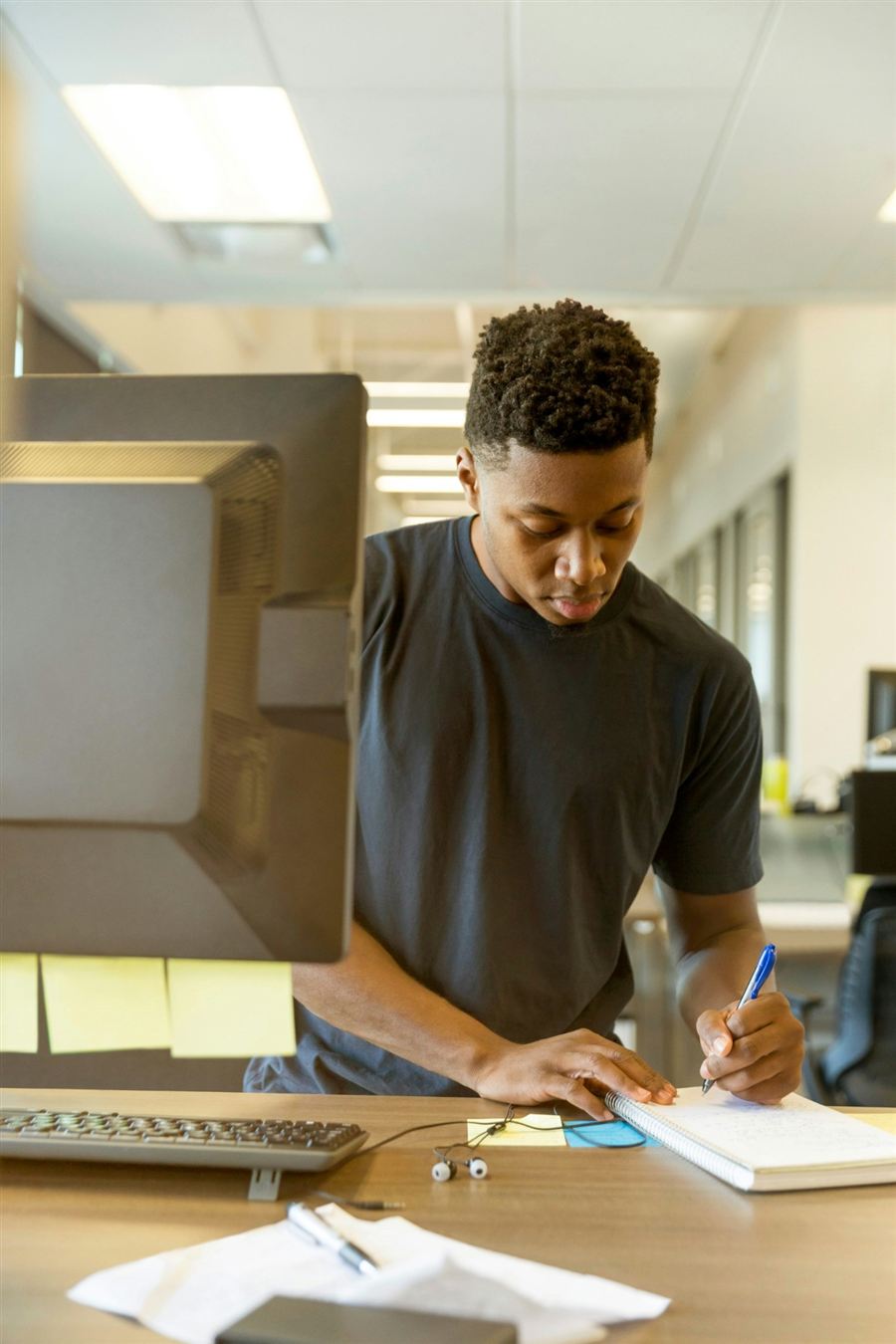 A man at a desk writing notes in a notebook
